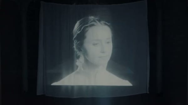 a ghostly projection of Rachael Lavelle from one of her music videos